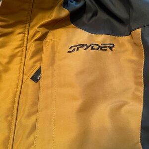 Spyder ski jacket. Black and deep gold color. 
Detachable hood.